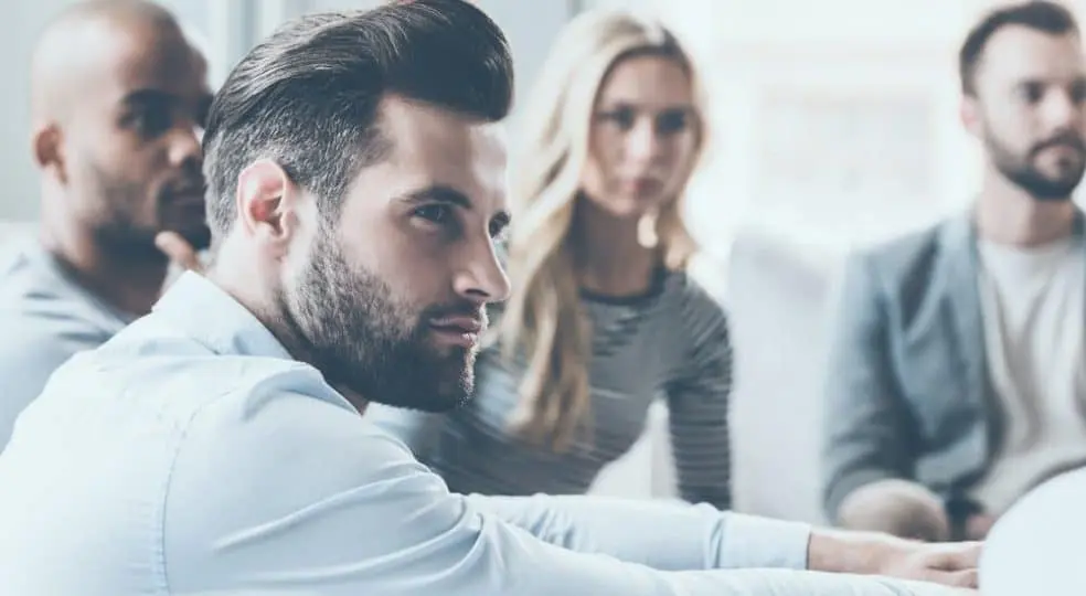 hombre rodeado de compañeros empresarios